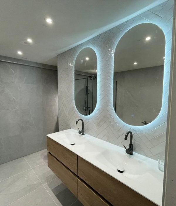 Moderne badkamer renovatie met witte tegels en glazen douche in Rotterdam